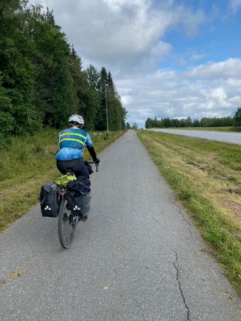 Rider in a neon jersey on a cycle path along a dike