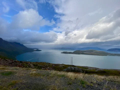 Fjord with islands under a dramatic sky, seen from a hill