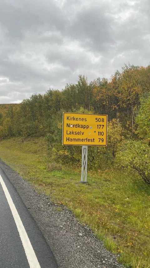 Yellow road sign: Kirkenes 508, Nordkapp 177, Lakselv 110, Hammerfest 79