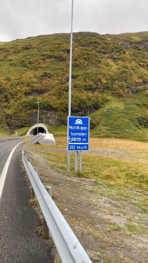 Blue sign "Nordkapptunnelen 6870 m, 212 m.u.h." at the tunnel portal